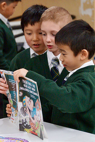 Grade 1 Students Enjoying A Book Together